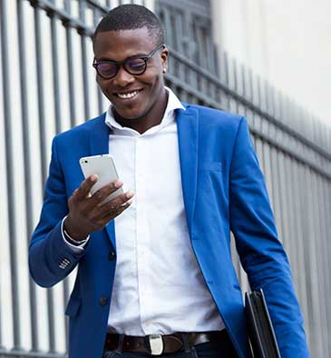 A man in a suit walking down the street with a notebook and briefcase