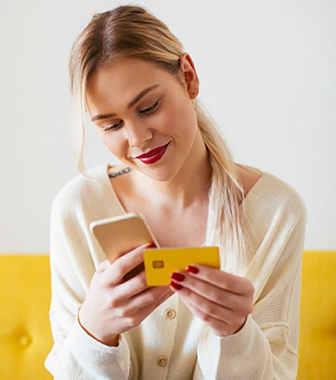 A woman holding her debit card to do her online banking